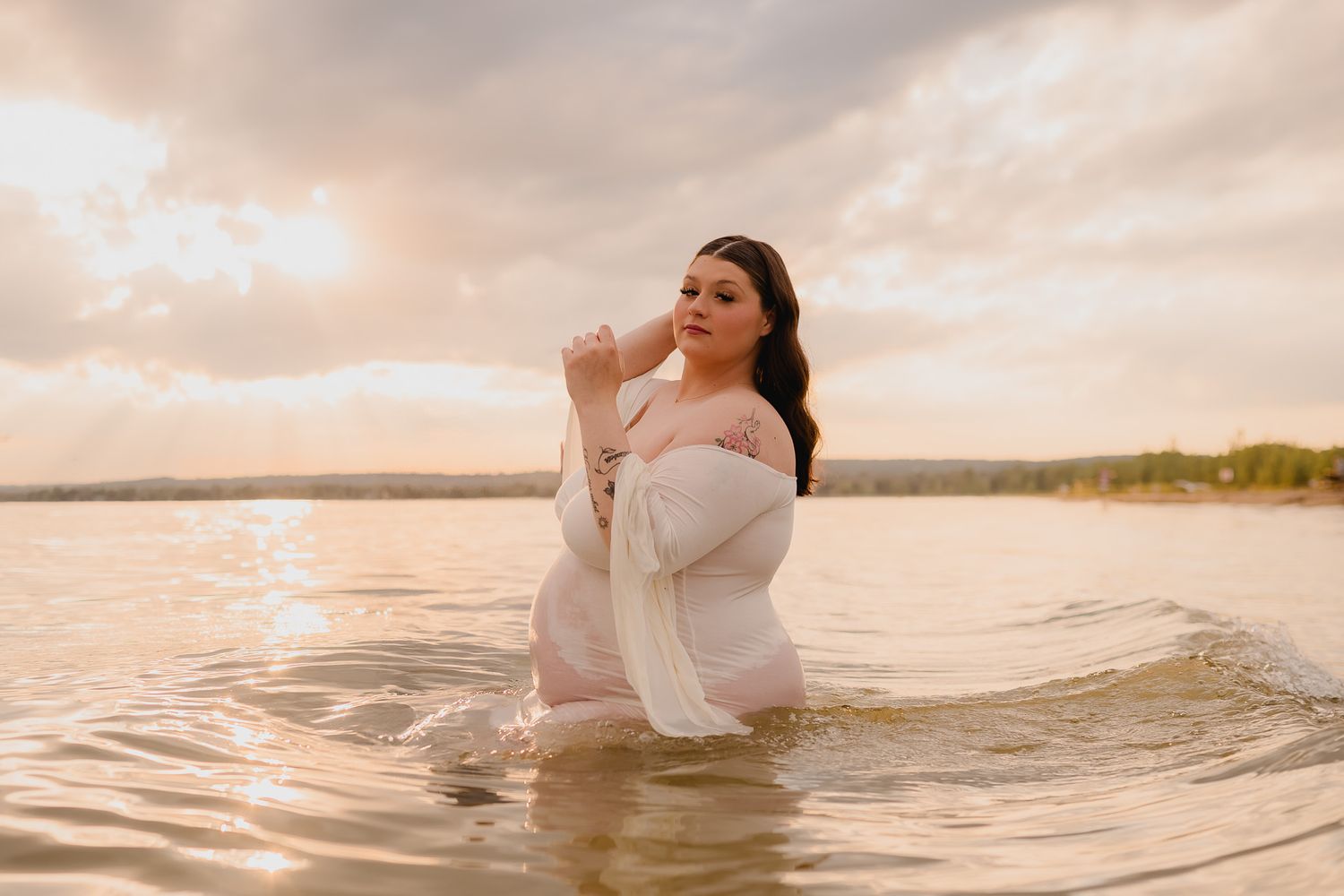 Ethereal beach photoshoot at sunset with flowing white dress in water. Maternity photographer Ontario