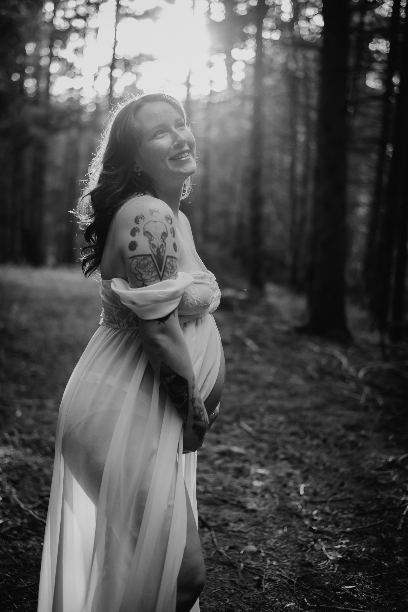 Artistic black and white forest maternity photos with ethereal flowing dress and natural lighting. Maternity photographer Ontario