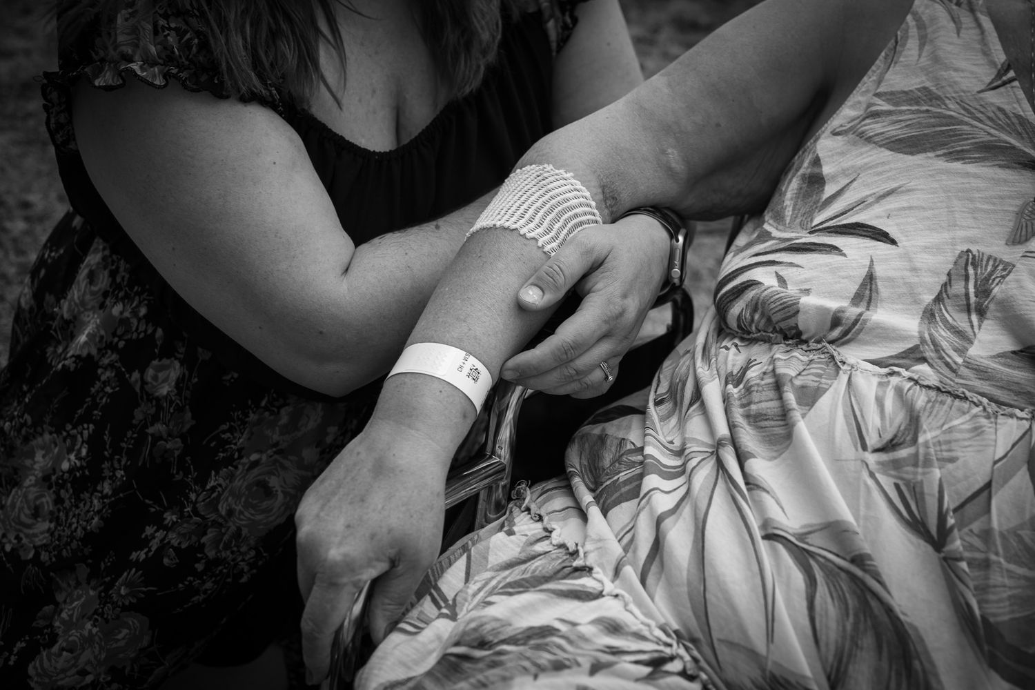 Close-up black and white images showing gentle hand interactions and care moments.