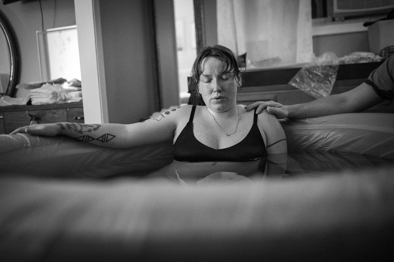 Black and white photograph showing quiet support during labor. Birth Photographer Ontario