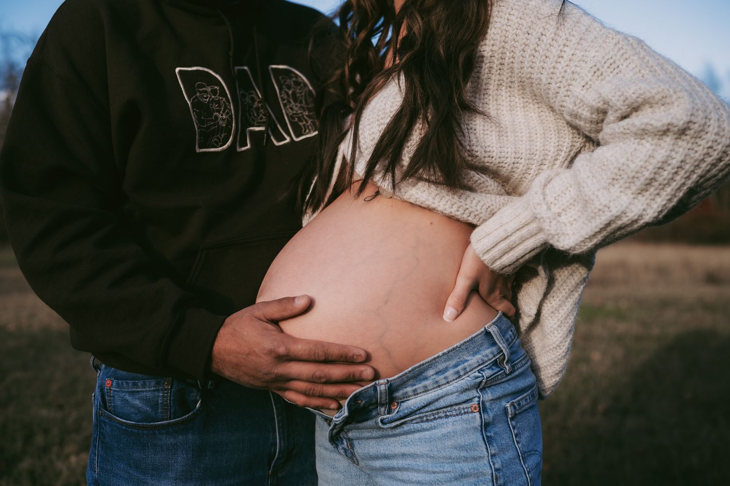 A series of intimate maternity photos showing a pregnant belly in natural outdoor lighting at sunset. Maternity photographer Ontario