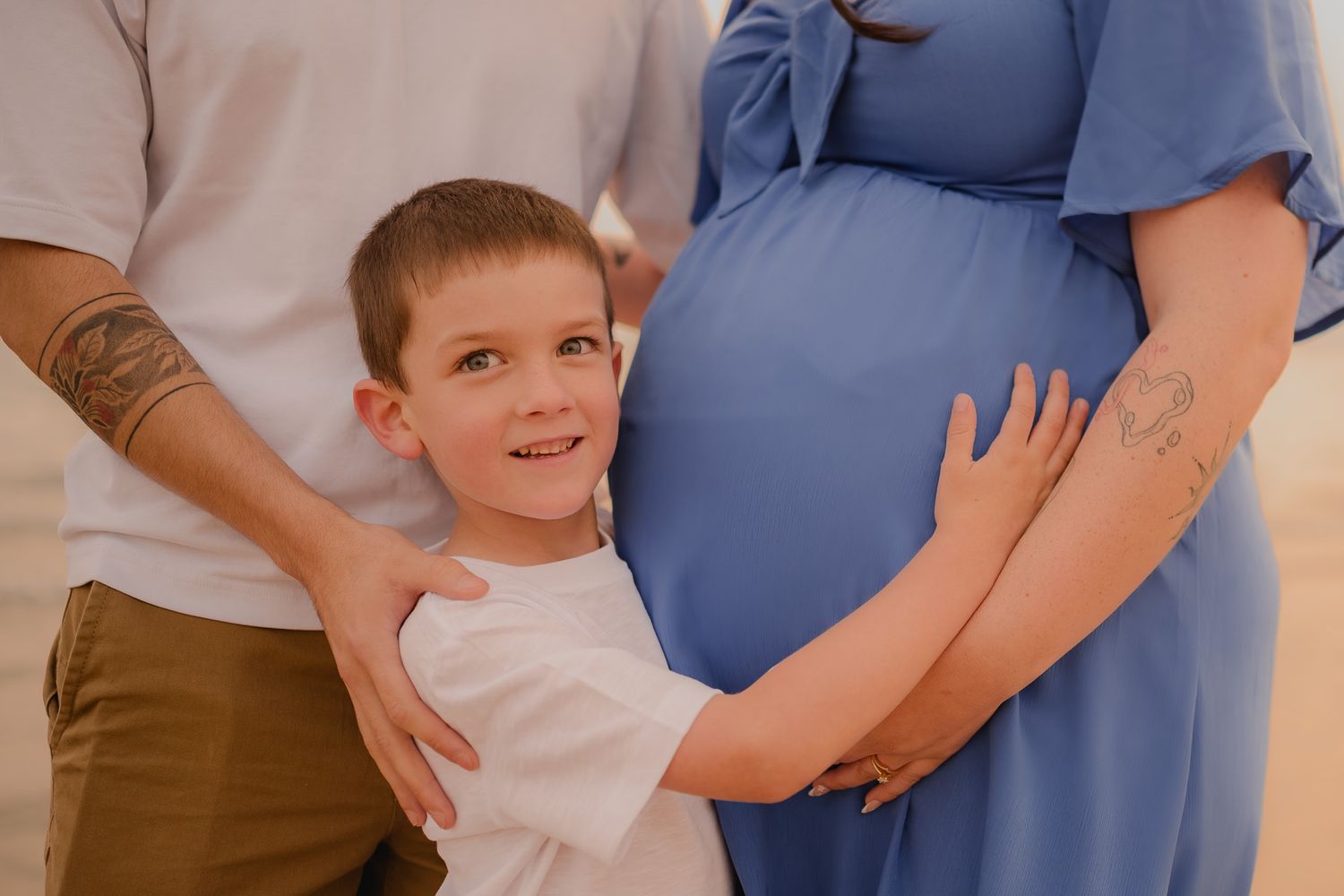 Family maternity photos on beach with blue dress and warm sunset tones. Maternity photographer Ontario