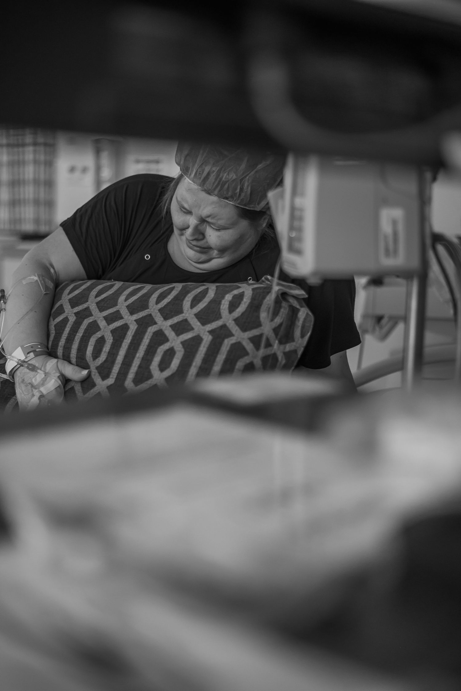 A black and white sequence of close-up shots showing someone working on a detailed task at a desk.