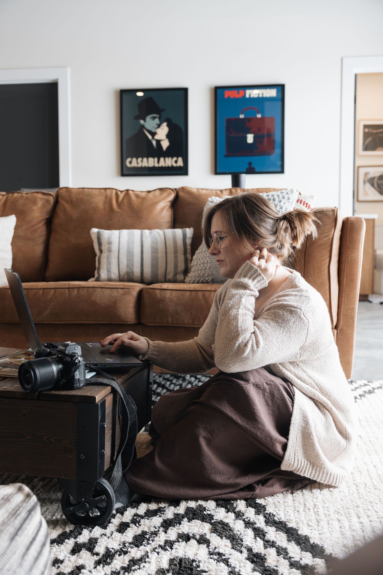 Person lounging on couch with camera and framed artwork on wall showing relaxed lifestyle photography scene.