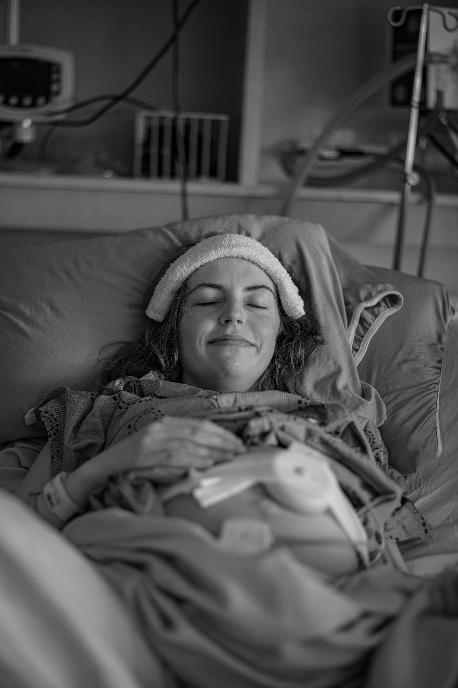 Patient sleeping peacefully in hospital bed with monitoring equipment attached. Birth Photographer Ontario
