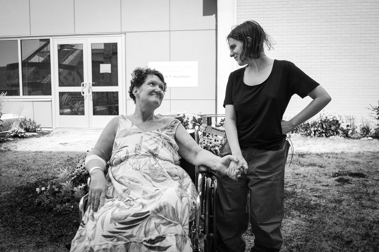 Black and white photo series showing supportive interaction between two people outside.