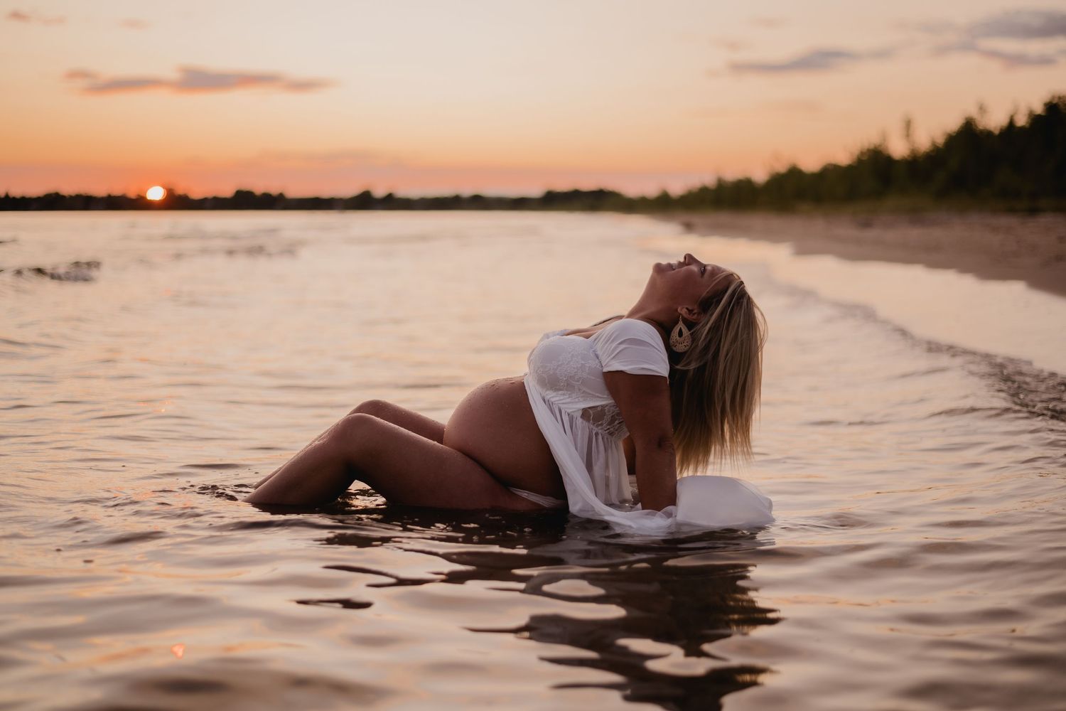 A dreamy maternity photo session in shallow water during a warm sunset. Maternity photographer Ontario