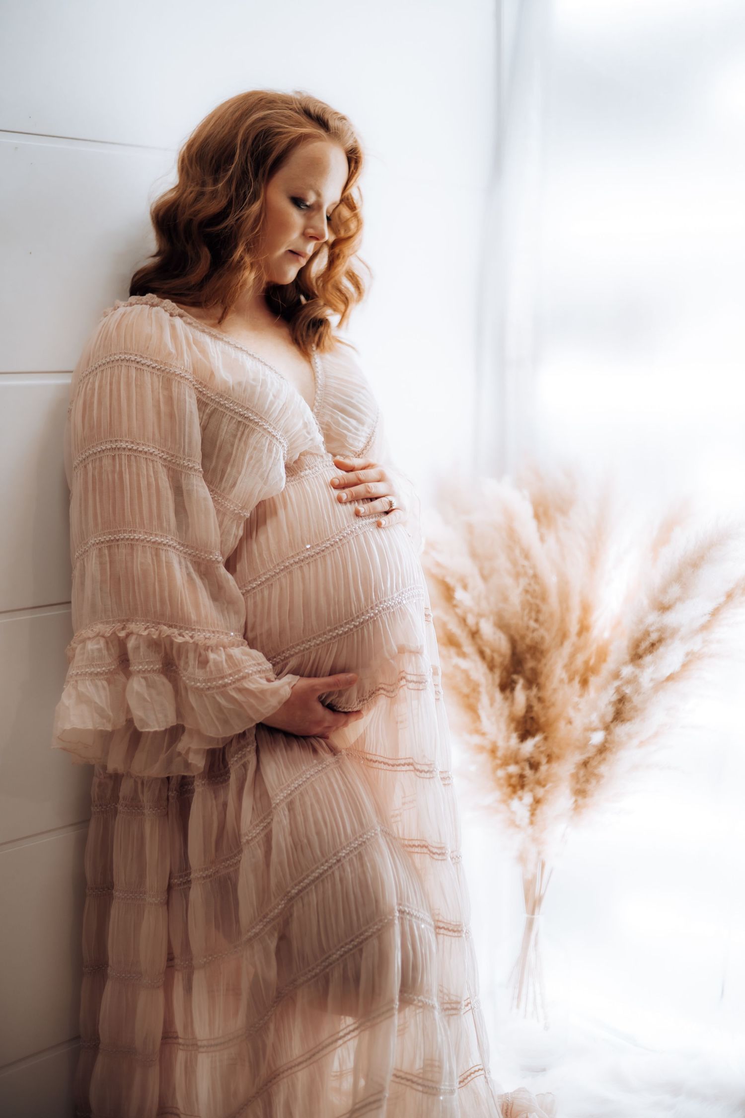 Intimate maternity portraits in romantic ruffled dress with natural window light. Maternity photographer Ontario