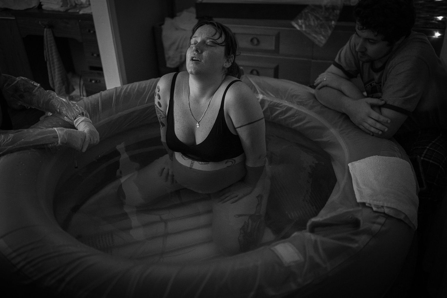 Candid black and white image showing comfort measures during childbirth. Birth Photographer Ontario