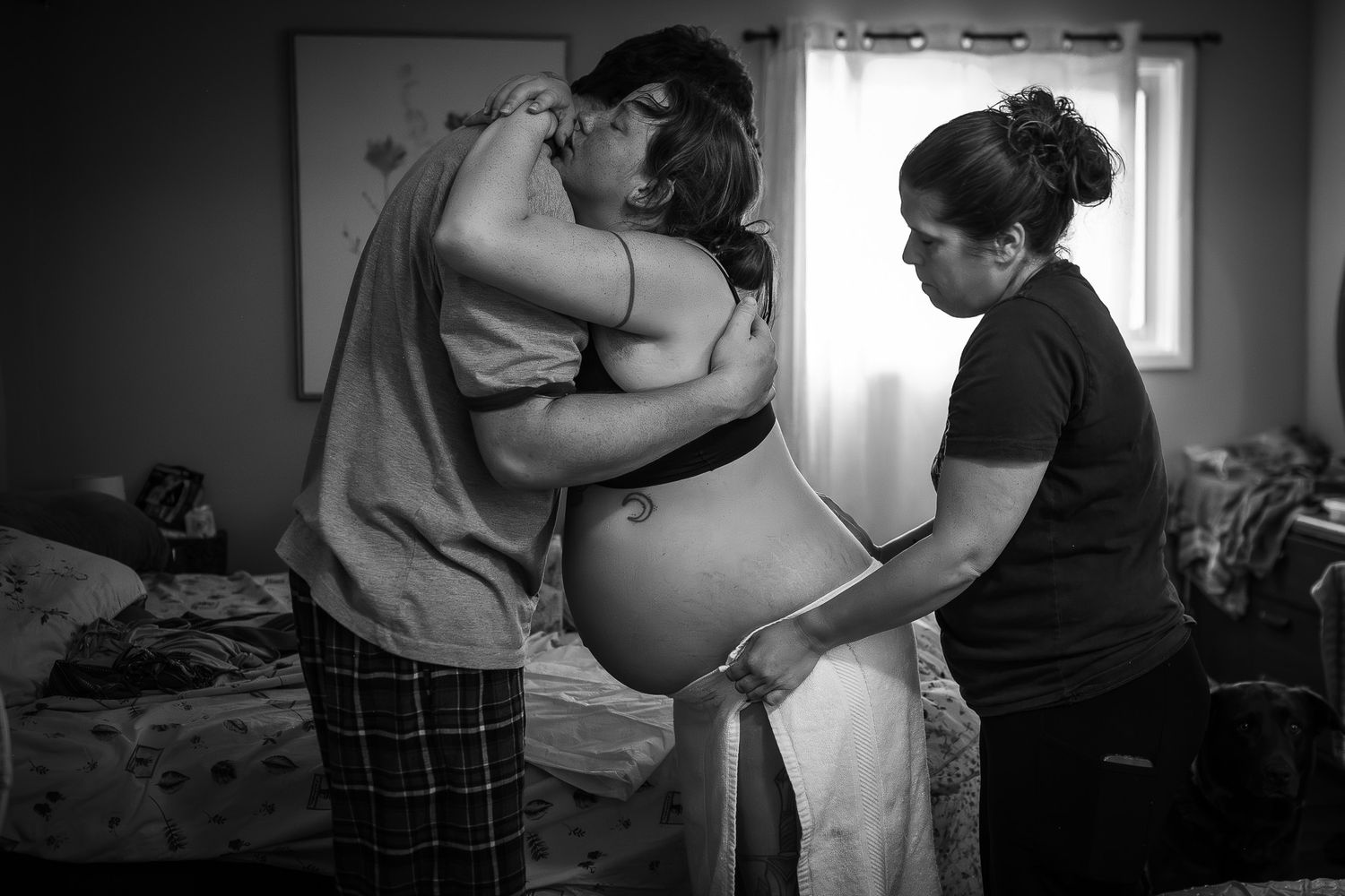 A tender moment captured in black and white during a home birth experience. Birth Photographer Ontario