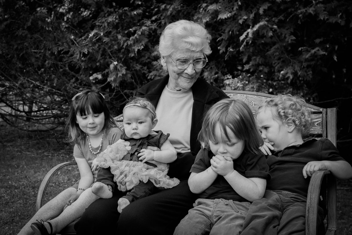 Black and white family portrait session in an outdoor garden setting.