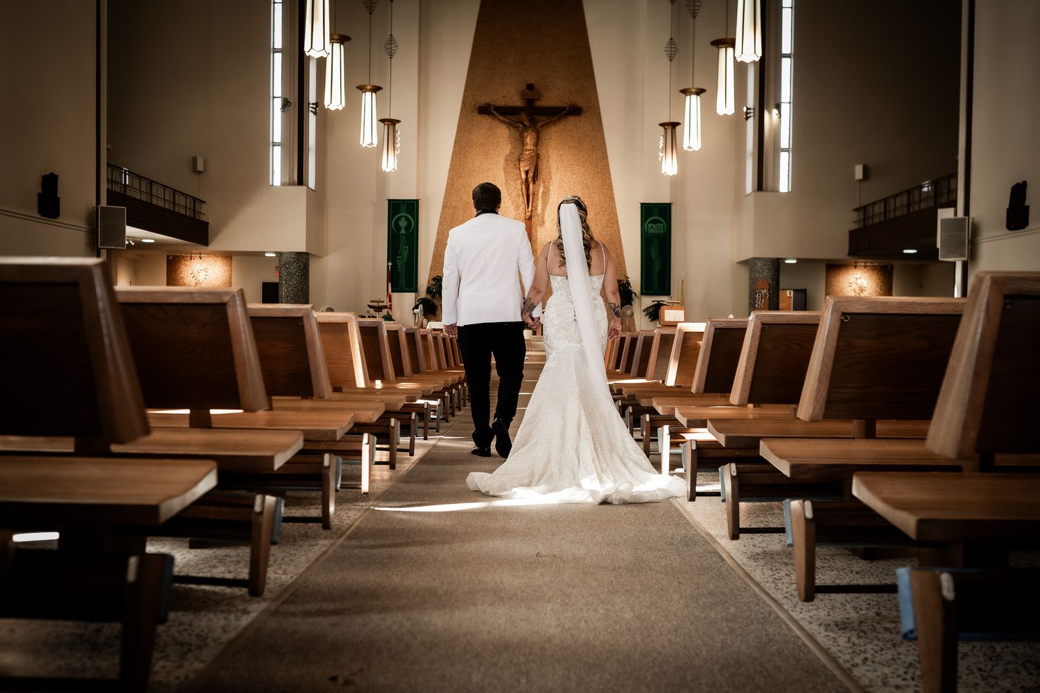 A wedding dress train trails elegantly across a modern restaurant floor with wooden tables and pendant lighting.
