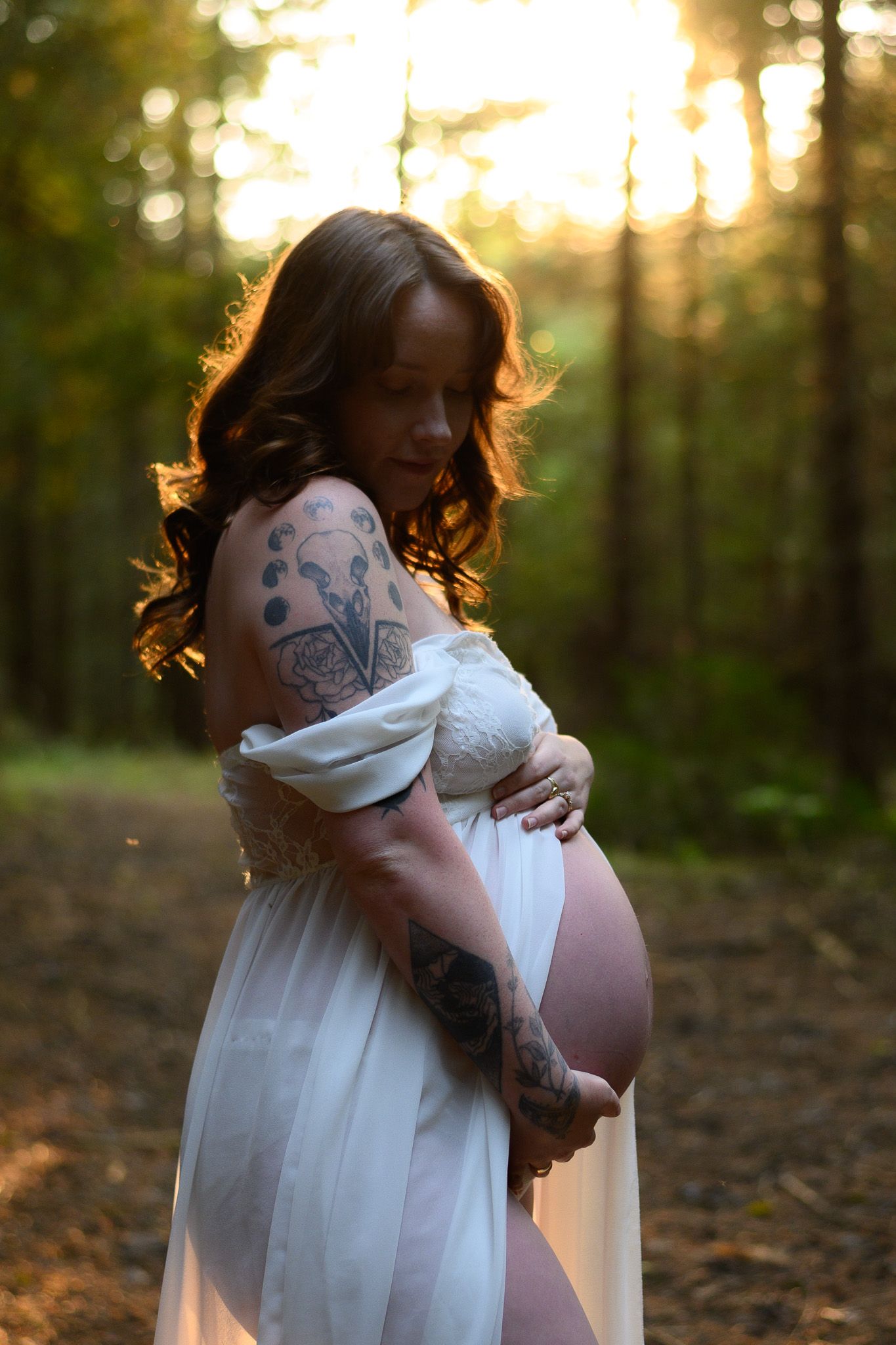Artistic maternity photography in forest with backlit sunset glow. Maternity photographer Ontario