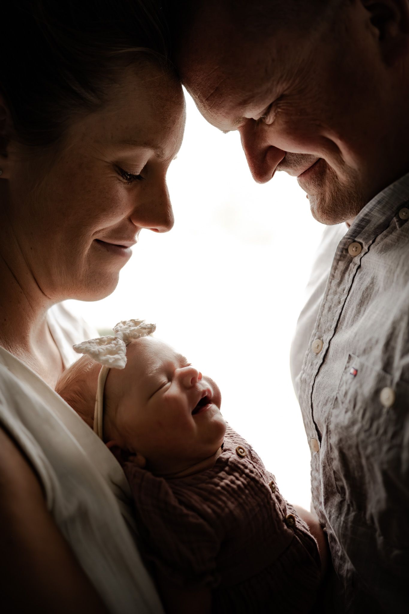 Intimate silhouette portraits capturing tender family moments in warm lighting.
