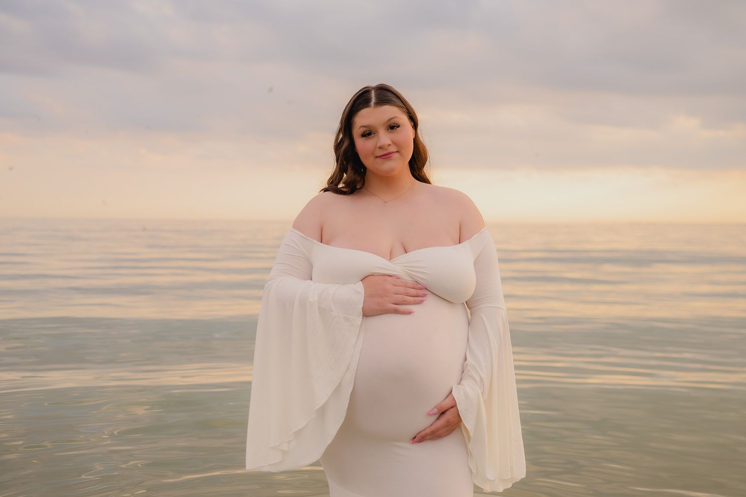 Serene maternity portrait session at beach during golden hour. Maternity photographer Ontario