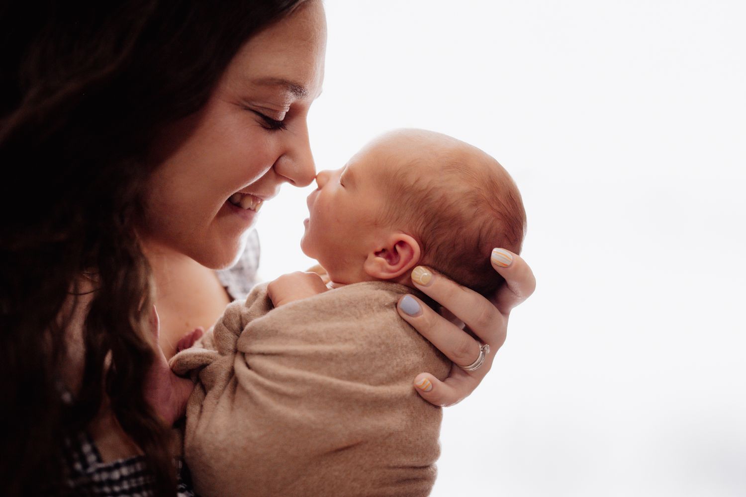 Tender moment with newborn baby against white background.