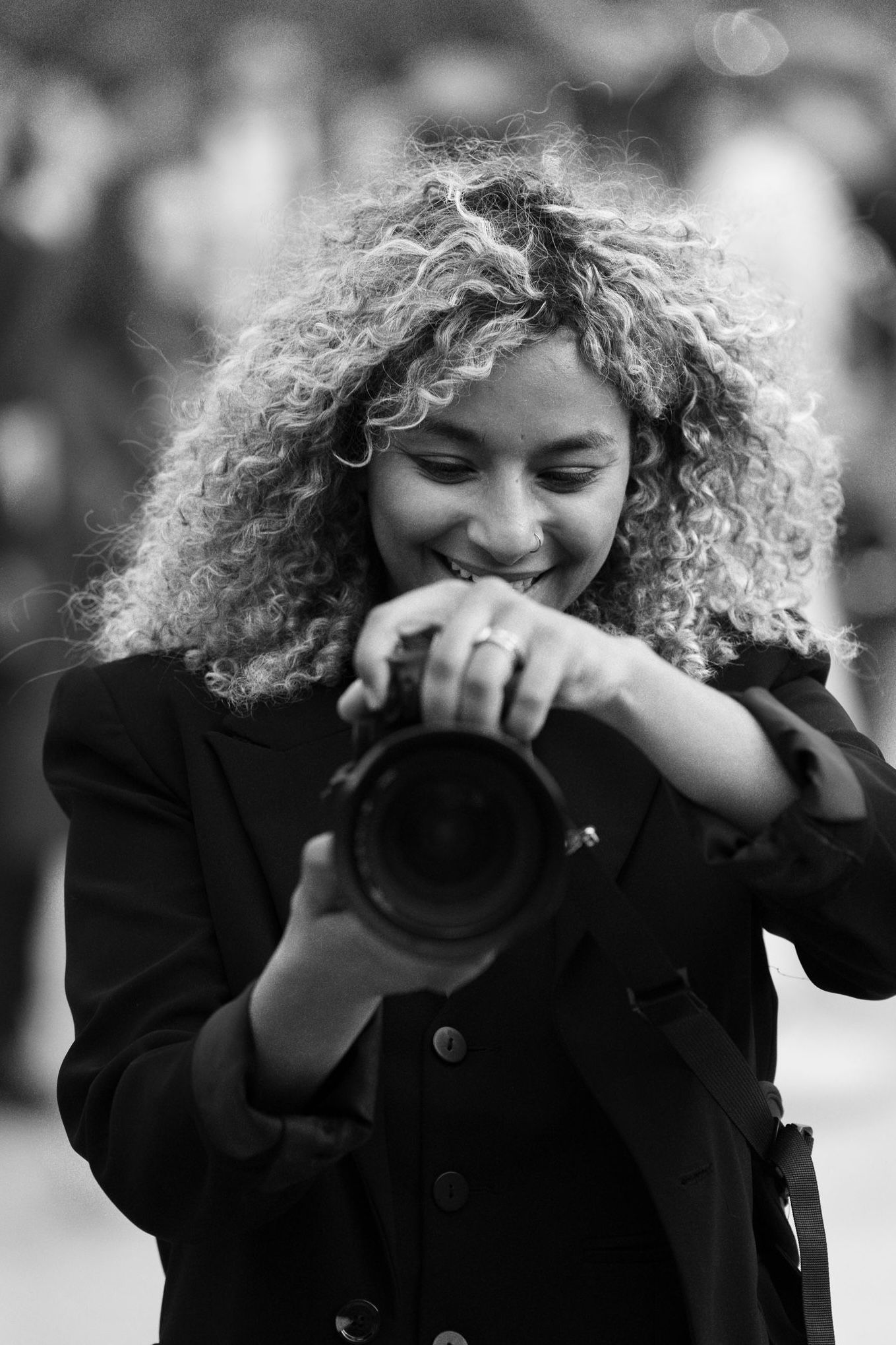 A series of black and white portraits showing joyful expressions with curly hair and natural lighting.