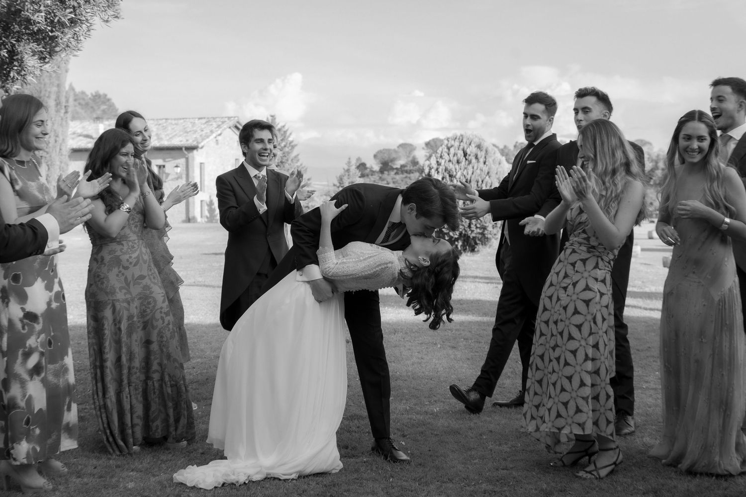 Wedding party celebrates with the newlyweds during an outdoor celebration.