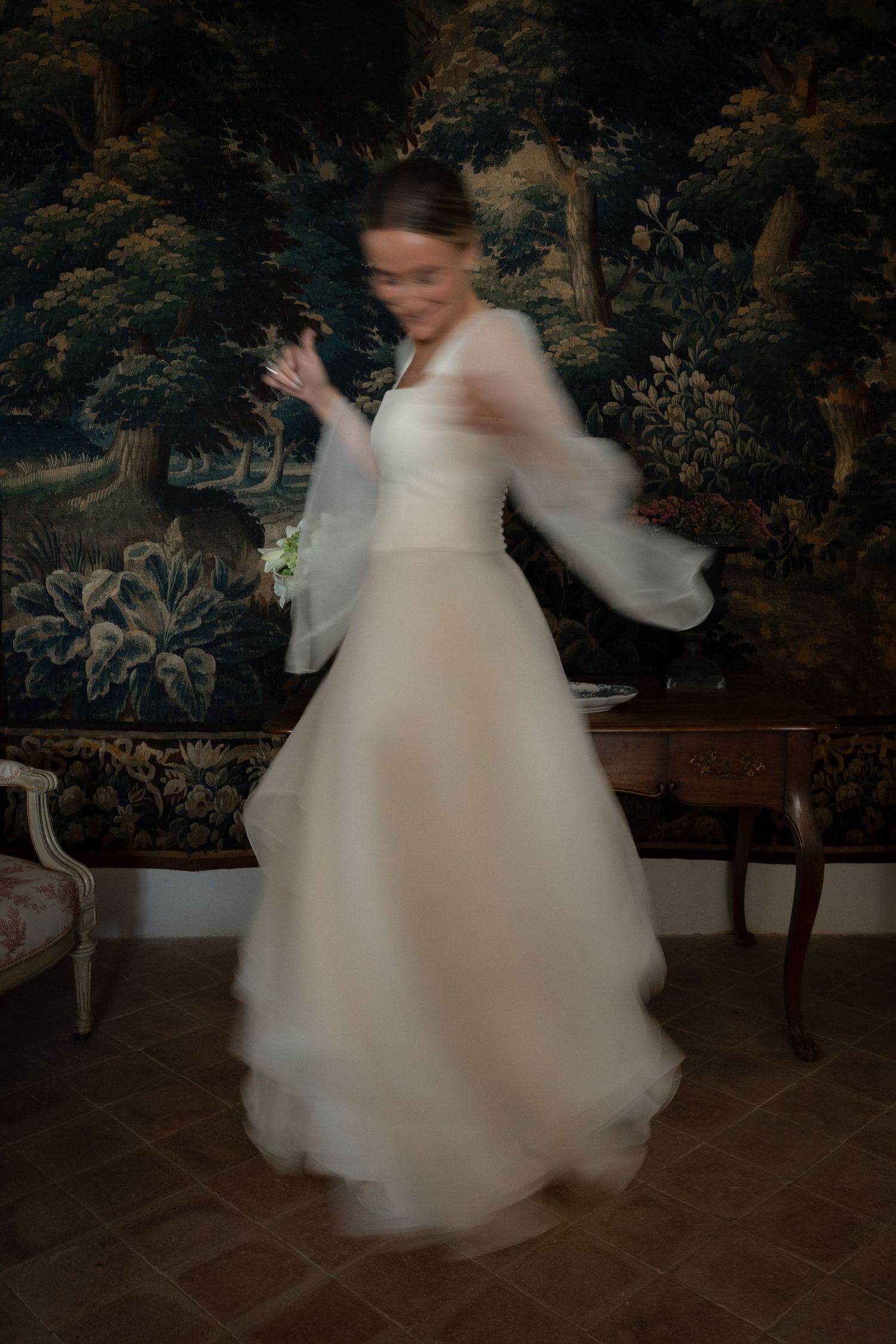 Motion blur of white wedding dress twirling in an elegant indoor setting.