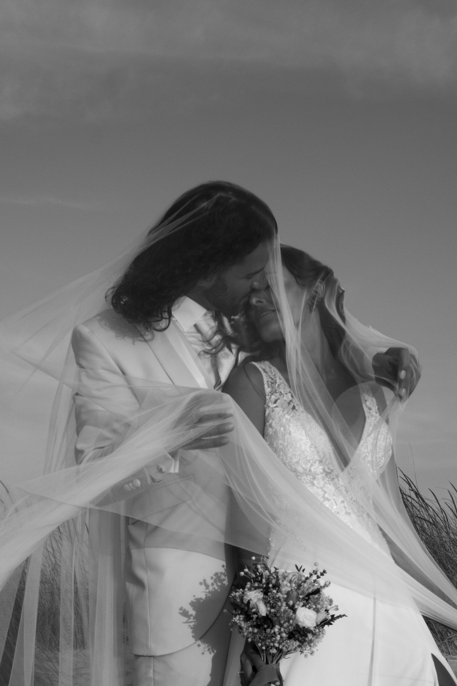 Artistic black and white image showing flowing veils and elegant wedding dresses in motion.