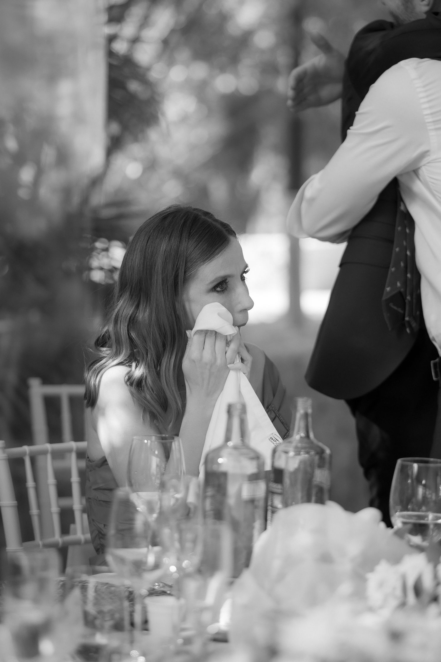 Black and white photo of guests enjoying conversation at an elegant dinner table.