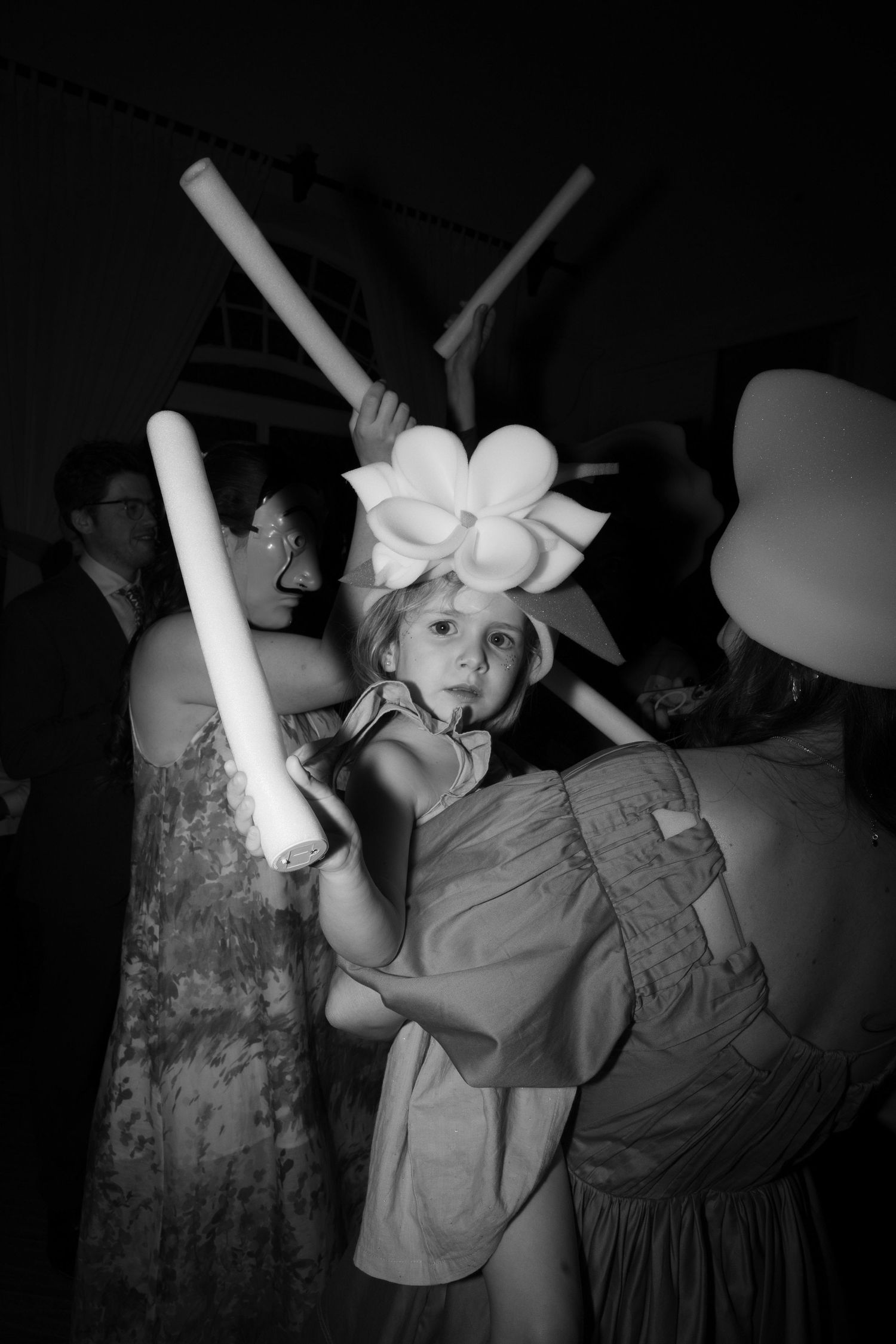 Children playing with glowsticks in a dark room during a celebration.