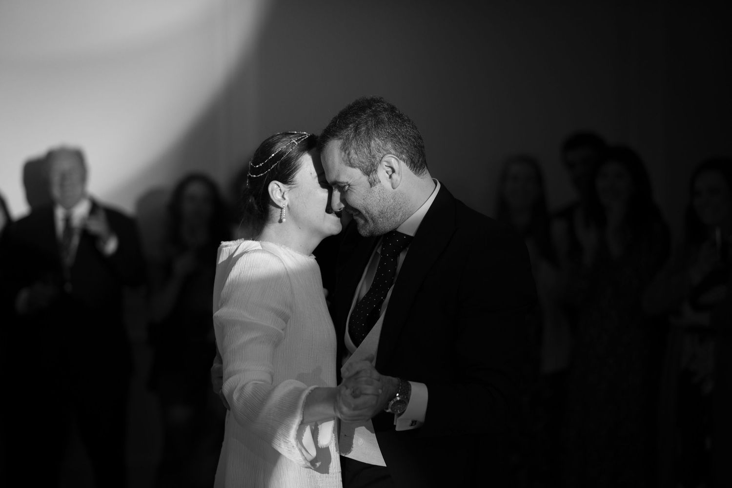 Silhouettes of a couple sharing an intimate dance moment at a party.