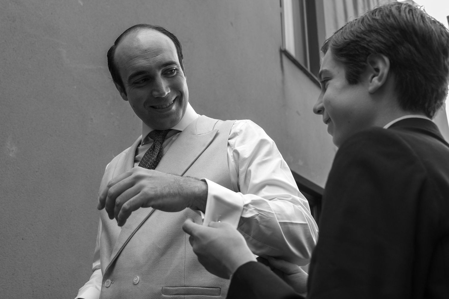 Two people engaged in conversation, one wearing a white shirt and one in dark clothing.