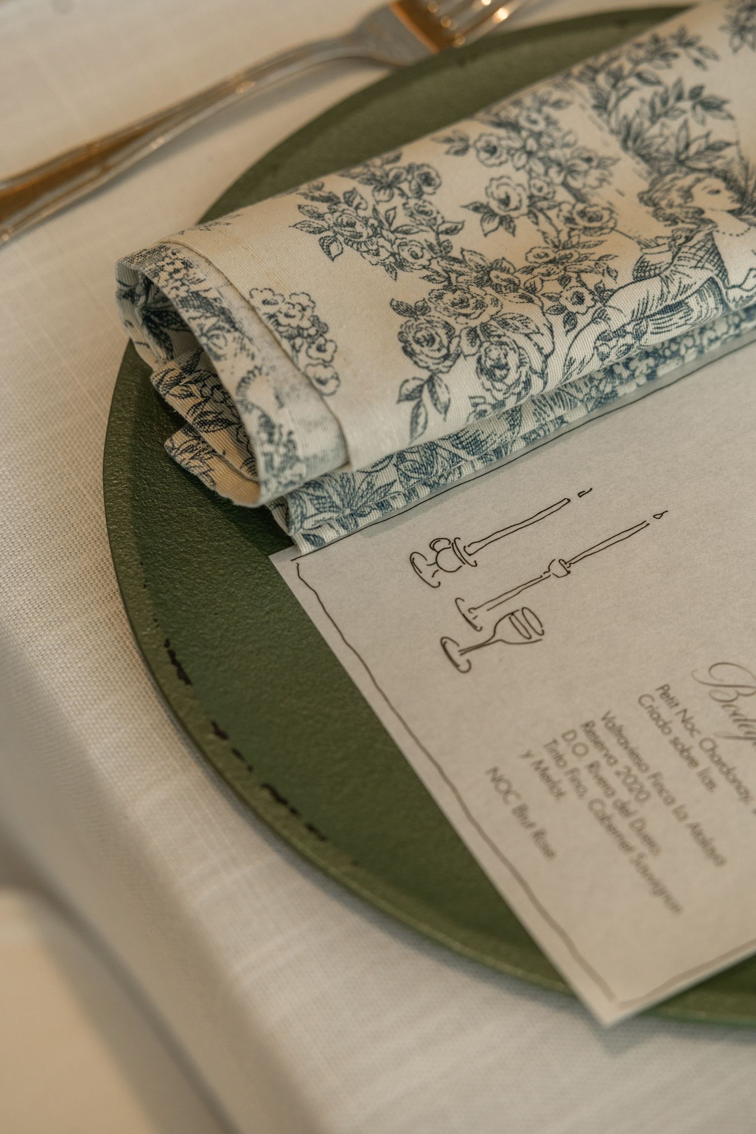 Vintage-style invitation cards with decorative floral designs placed on a dark green surface.