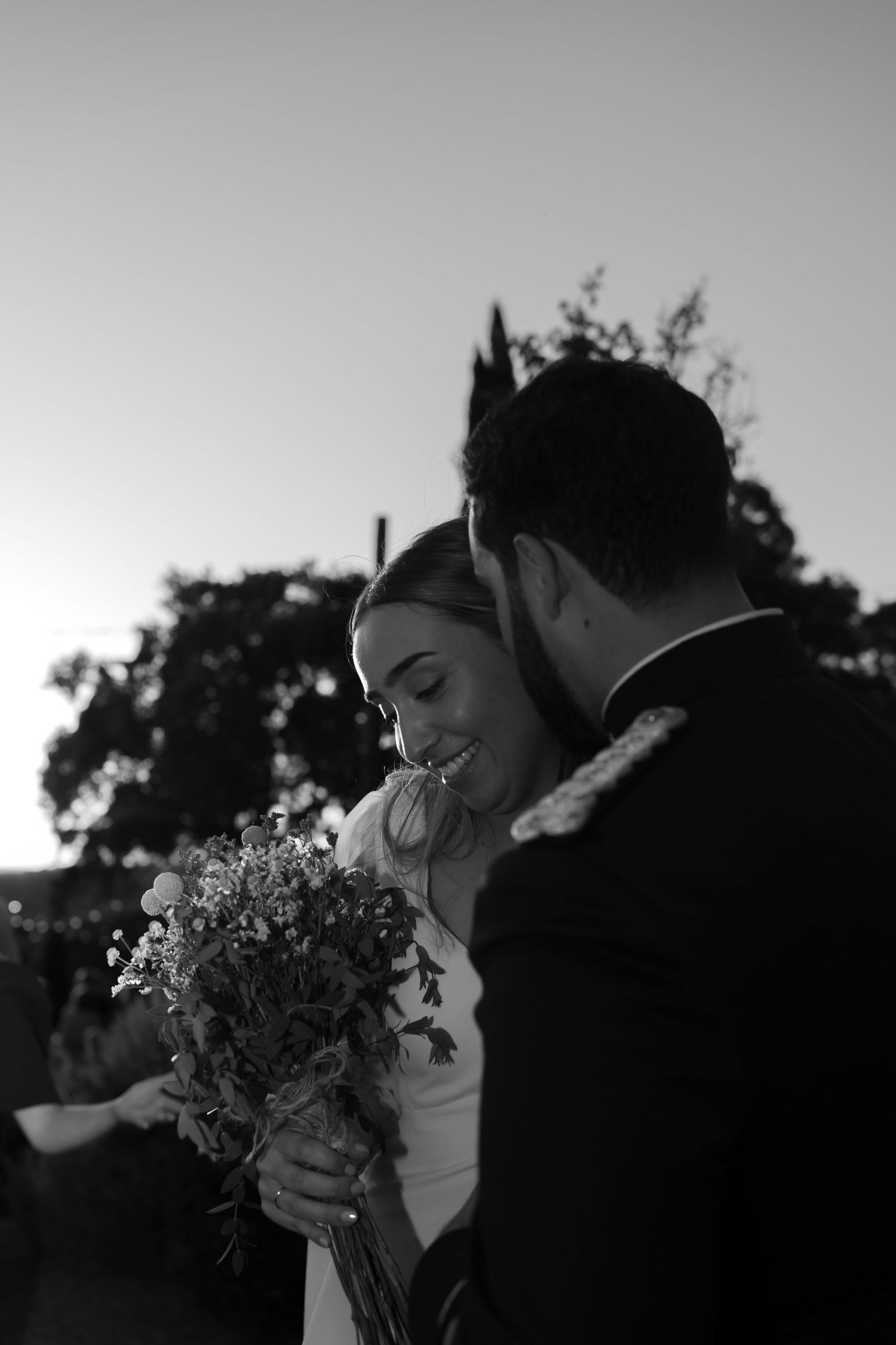 Black and white photos capturing intimate moments between a couple with a wildflower bouquet.