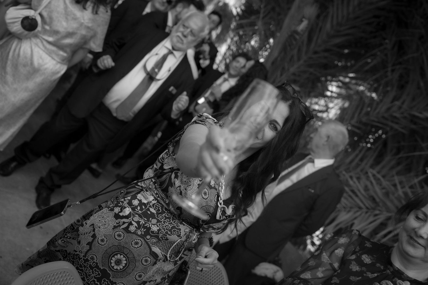 Wedding guests dance enthusiastically on an outdoor dance floor during evening reception.