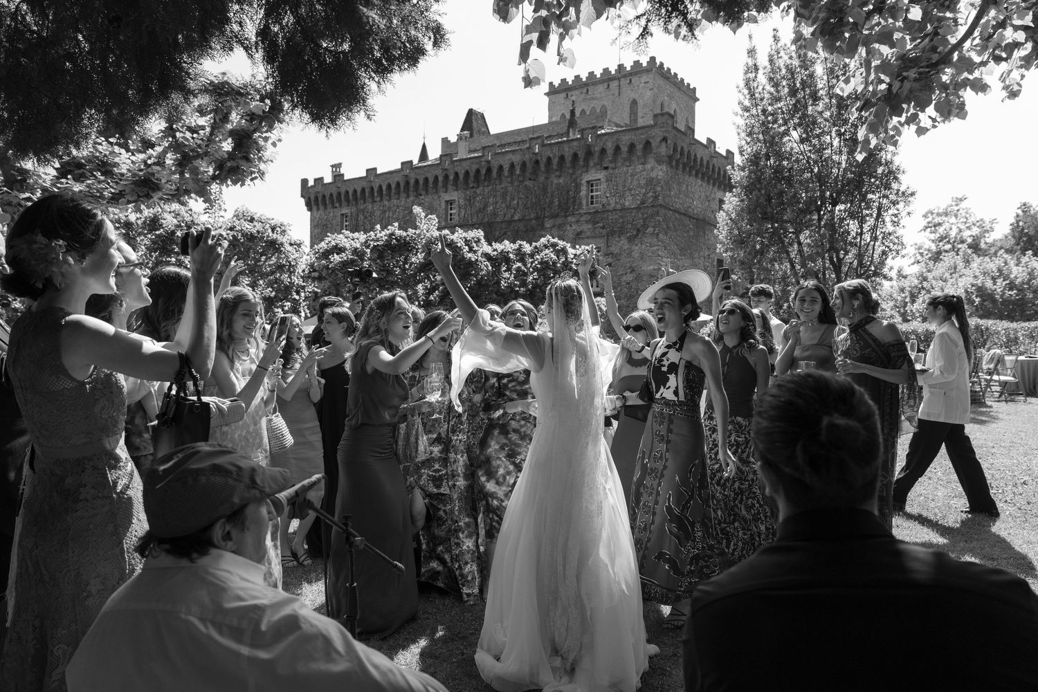 Black and white photo of wedding guests celebrating outdoors.