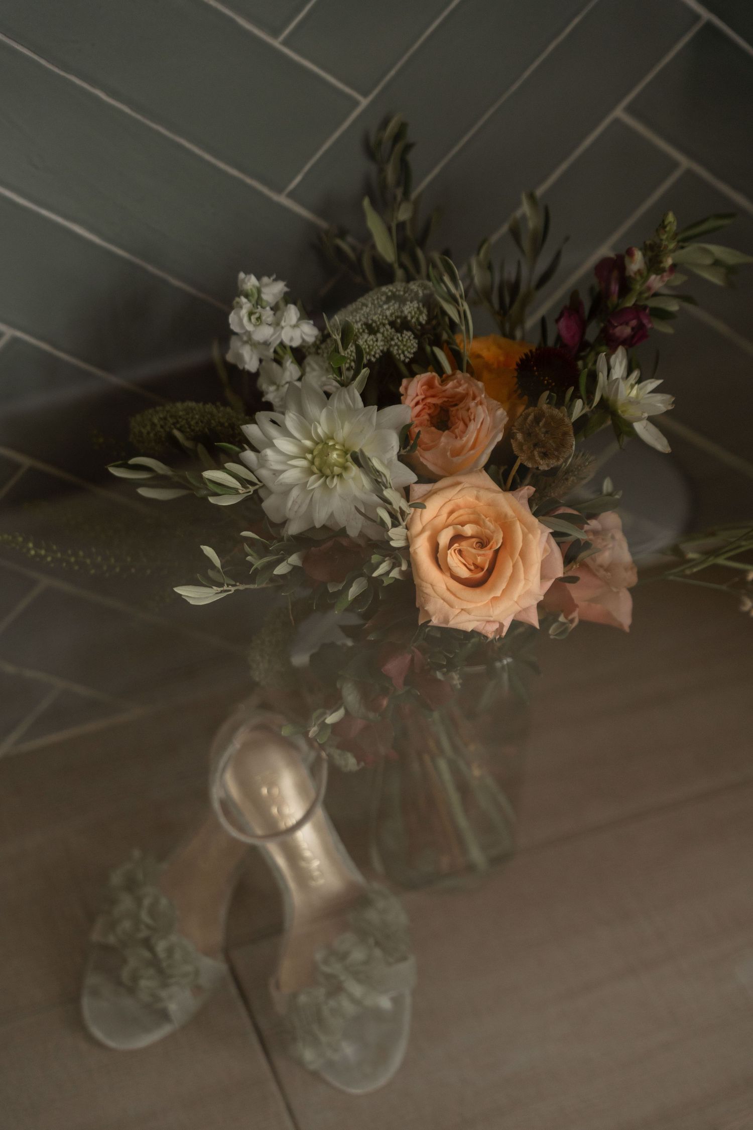 Delicate floral arrangements with peach roses and white flowers in glass vases.