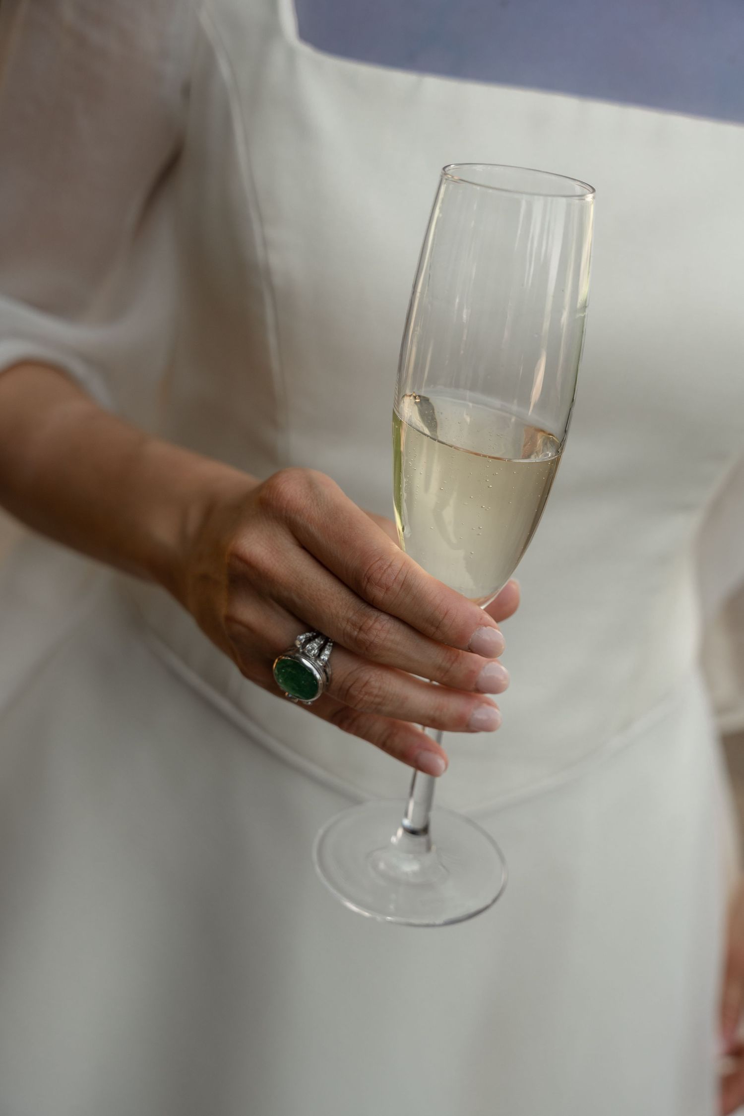 Hand holding a champagne flute against a white background.