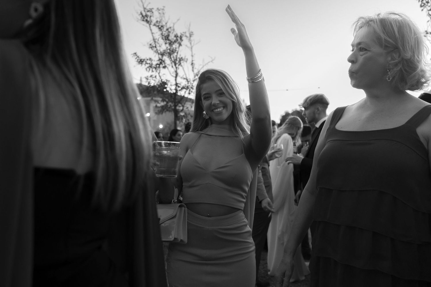 Joyful celebration at an outdoor party with people dancing and smiling in black and white.