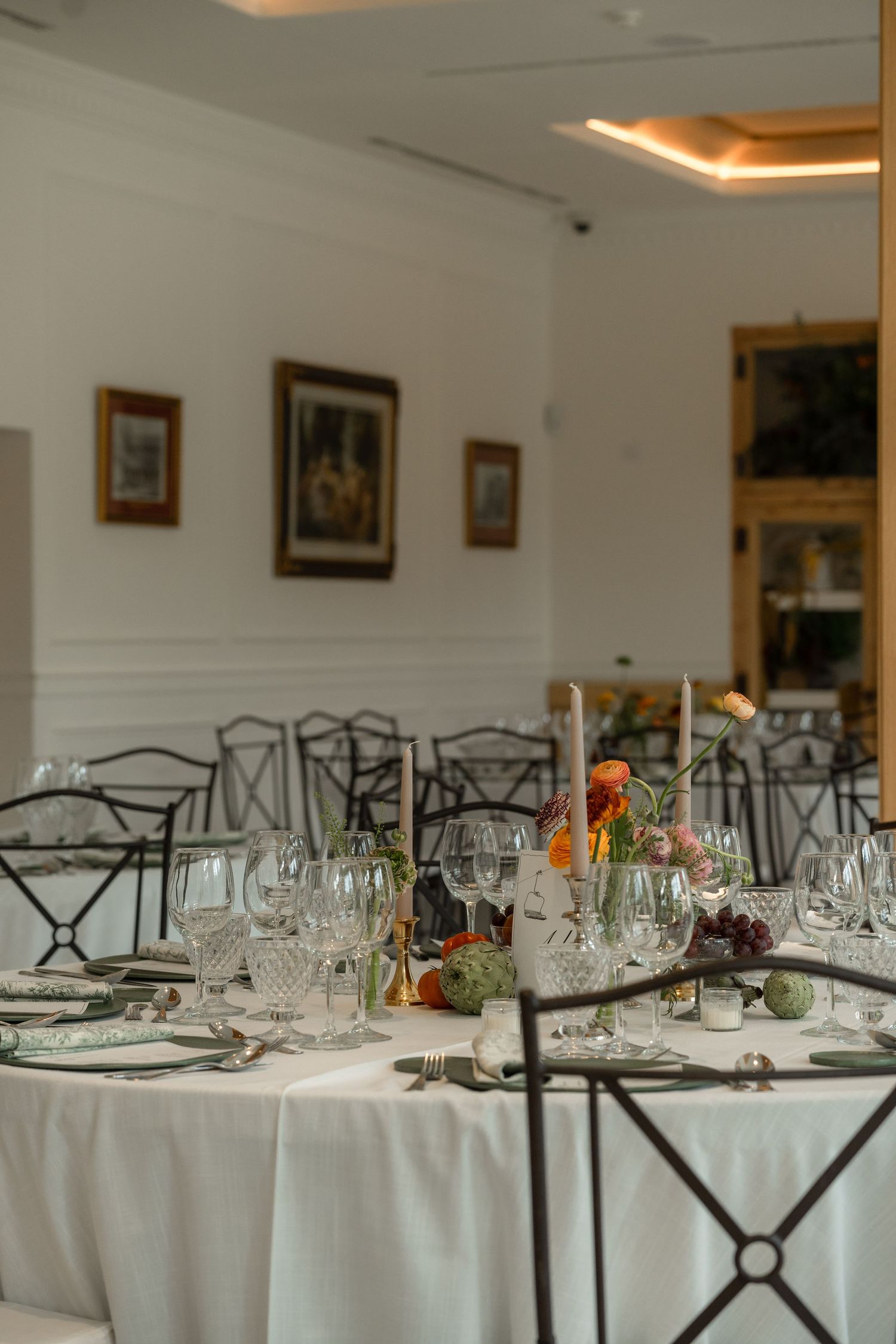 Elegant wedding reception tables set with crystal glassware and white linens.
