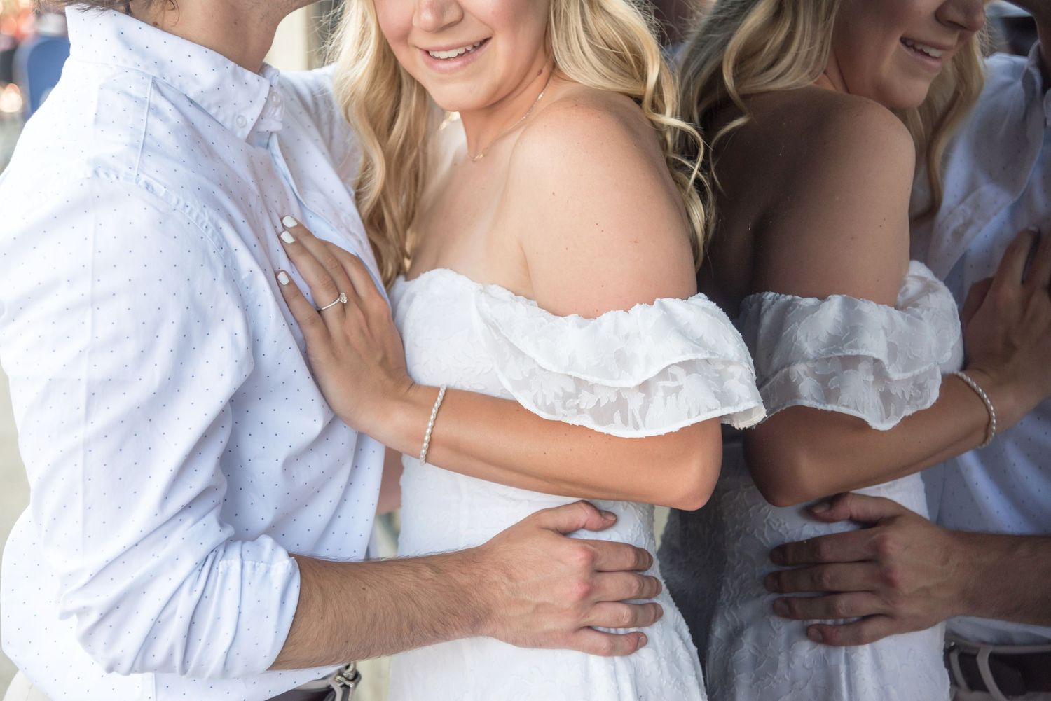 Group embracing in white outfits during an outdoor celebration.
