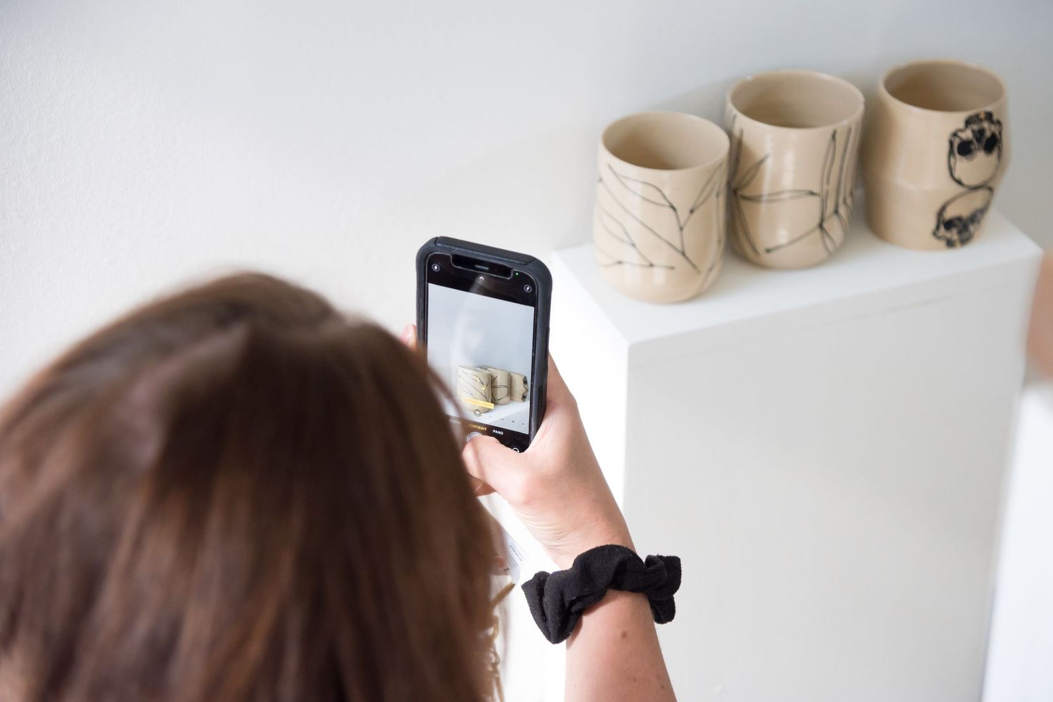 Behind the scenes photography setup with ceramic mugs on white background.