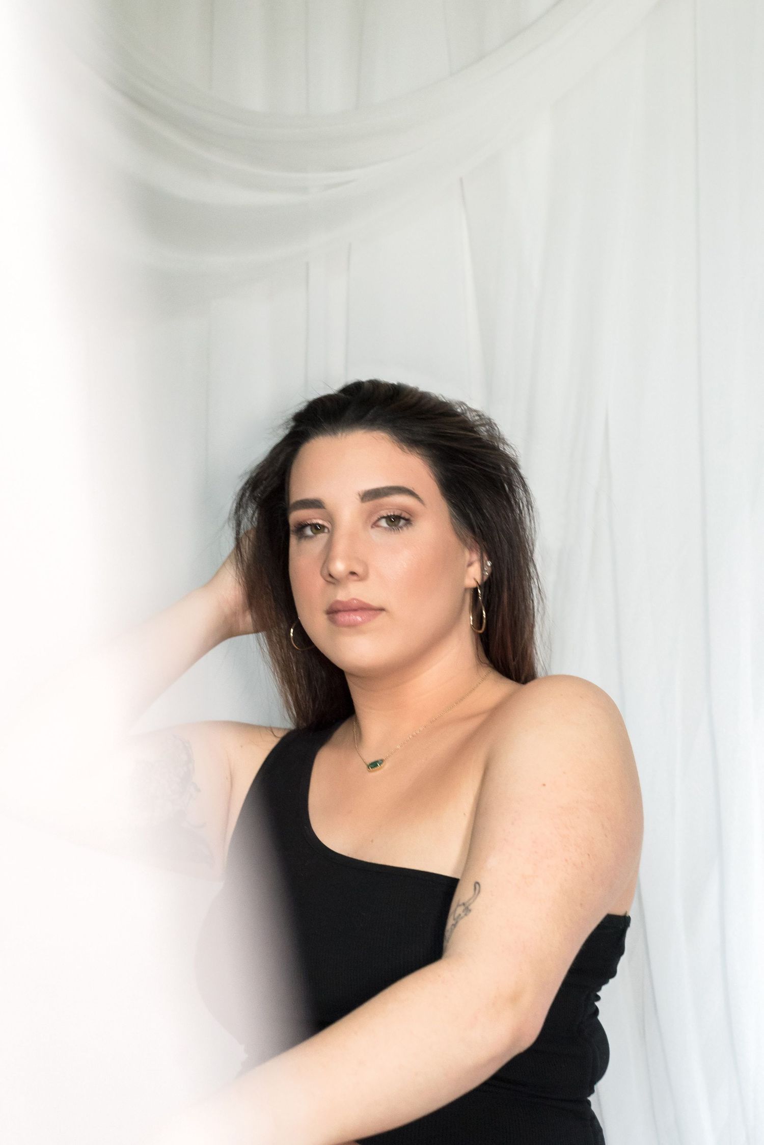 Artistic portrait series against white backdrop showing dramatic poses in black clothing.
