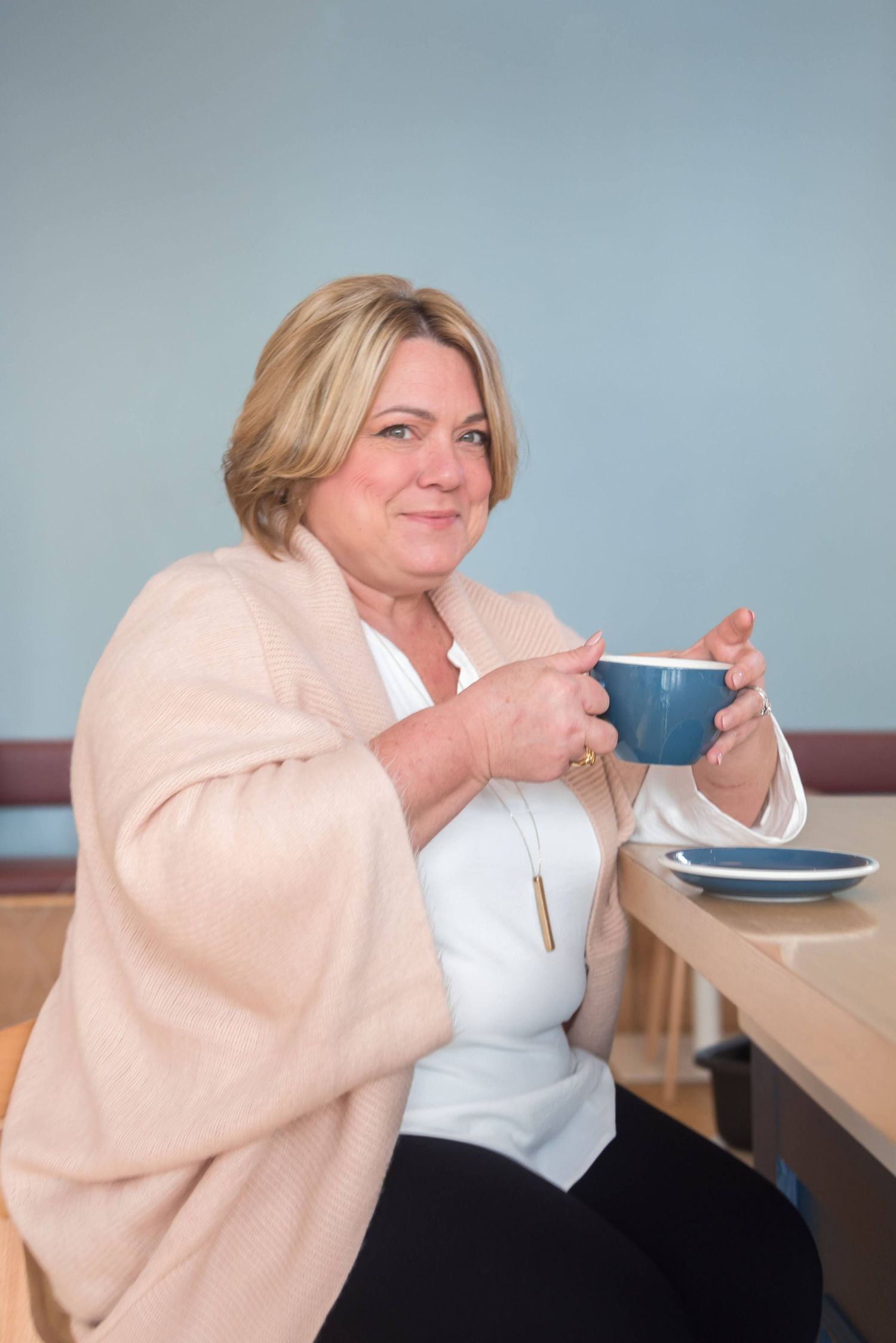Person enjoying meal at casual dining table wearing cozy beige sweater.
