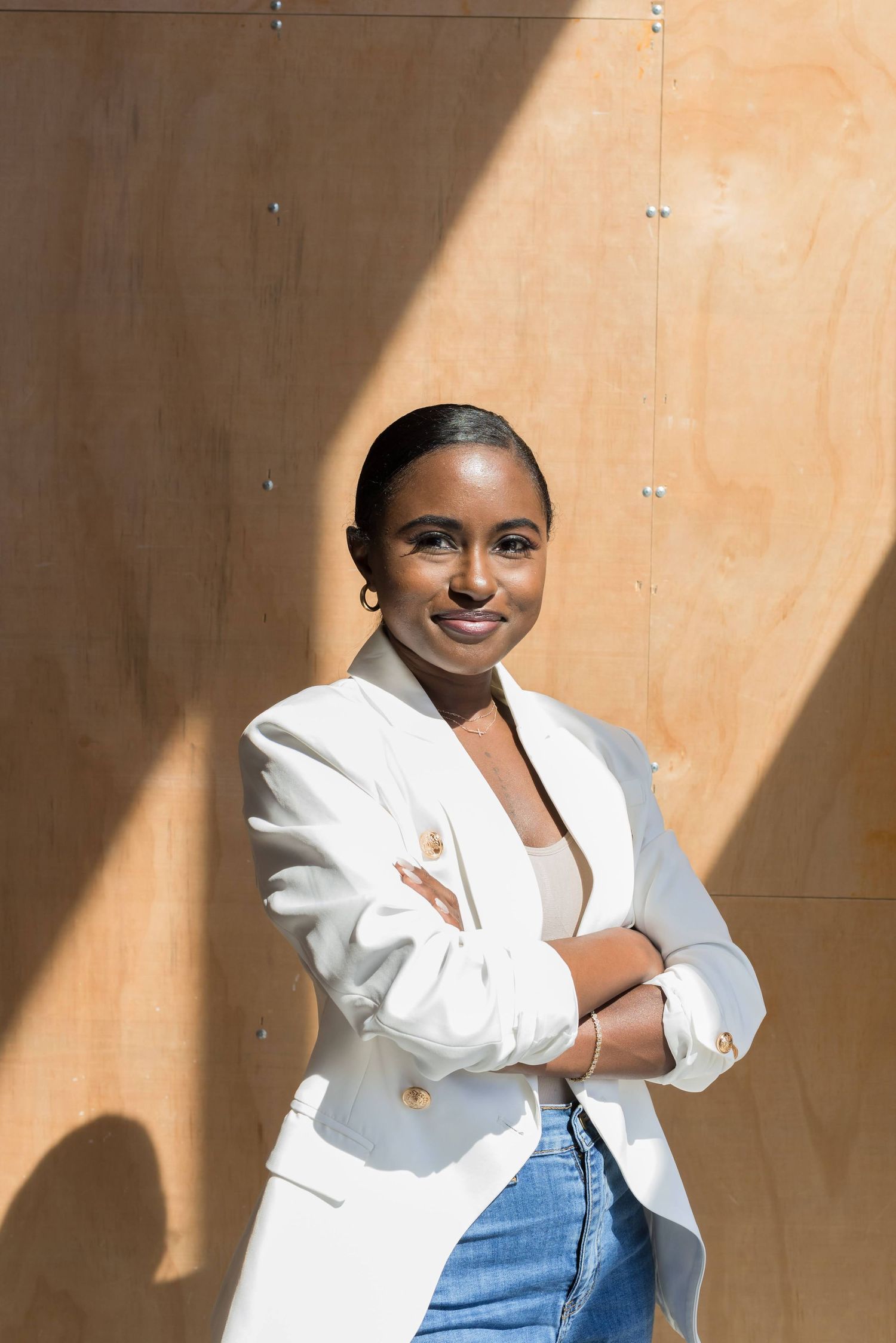 Professional portraits against a peach wall with dramatic lighting and shadows.