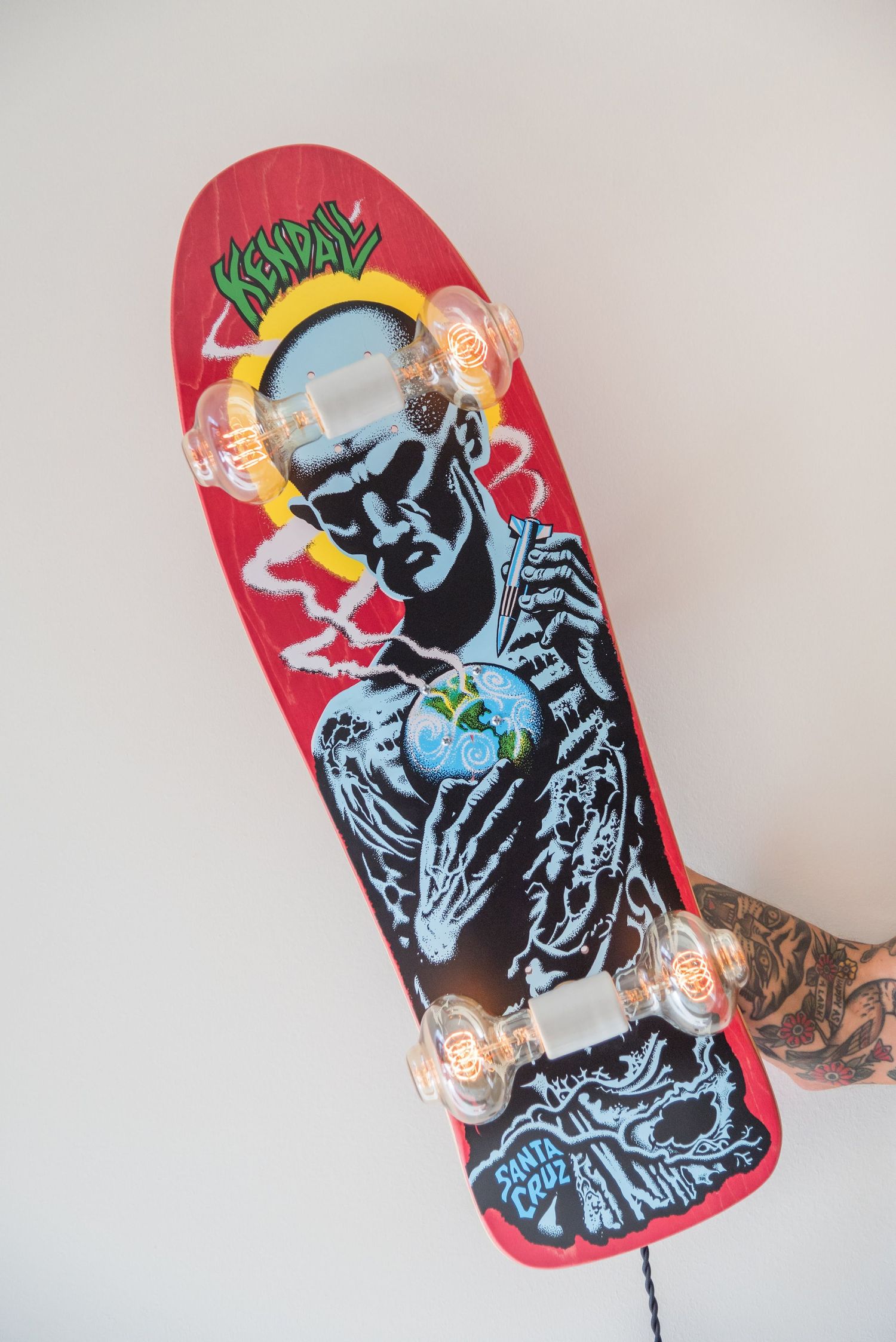 Red skateboard deck featuring artistic graffiti-style design in blue and black.