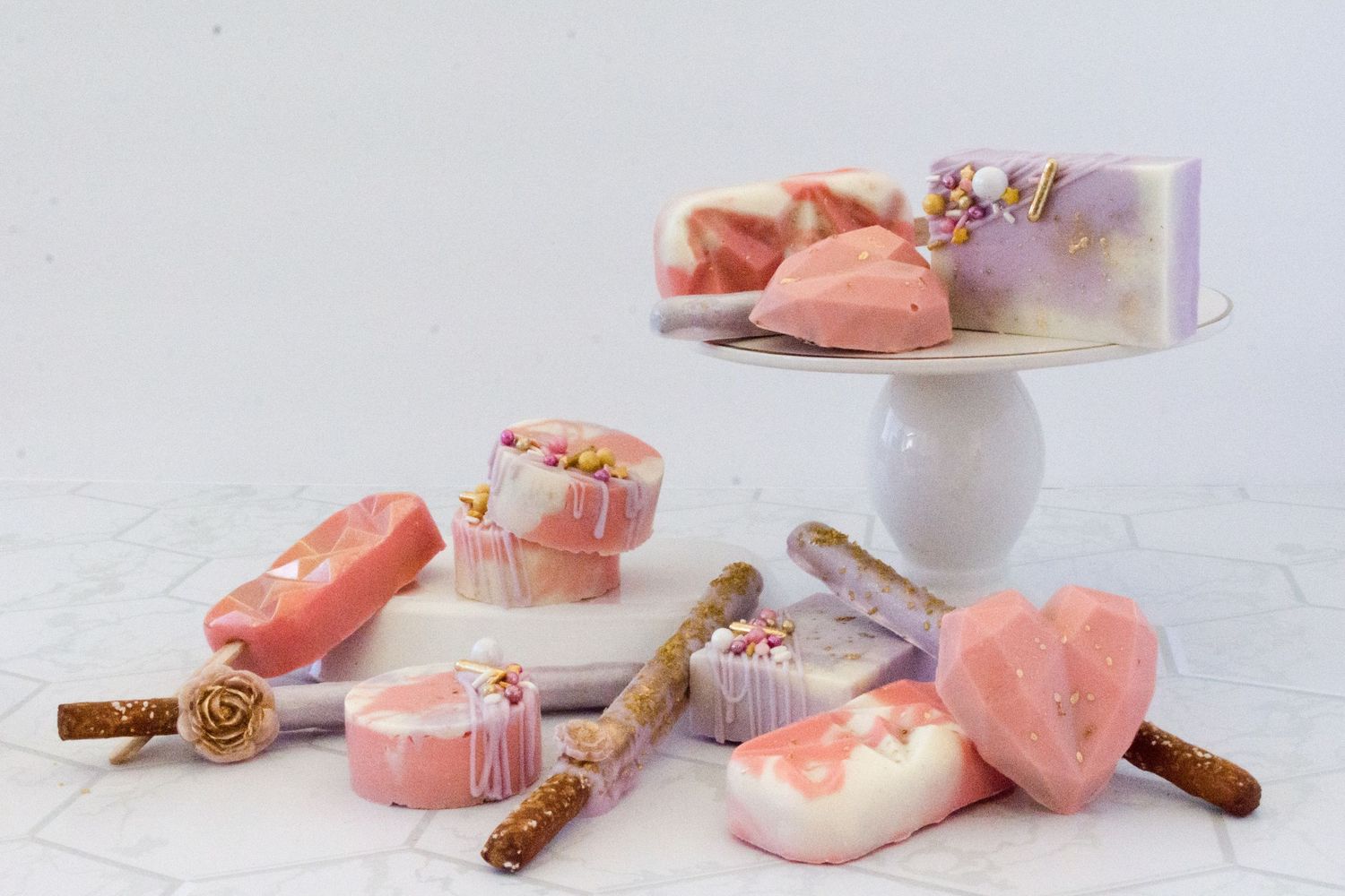 Pink heart-shaped candies and cinnamon sticks arranged on white background.