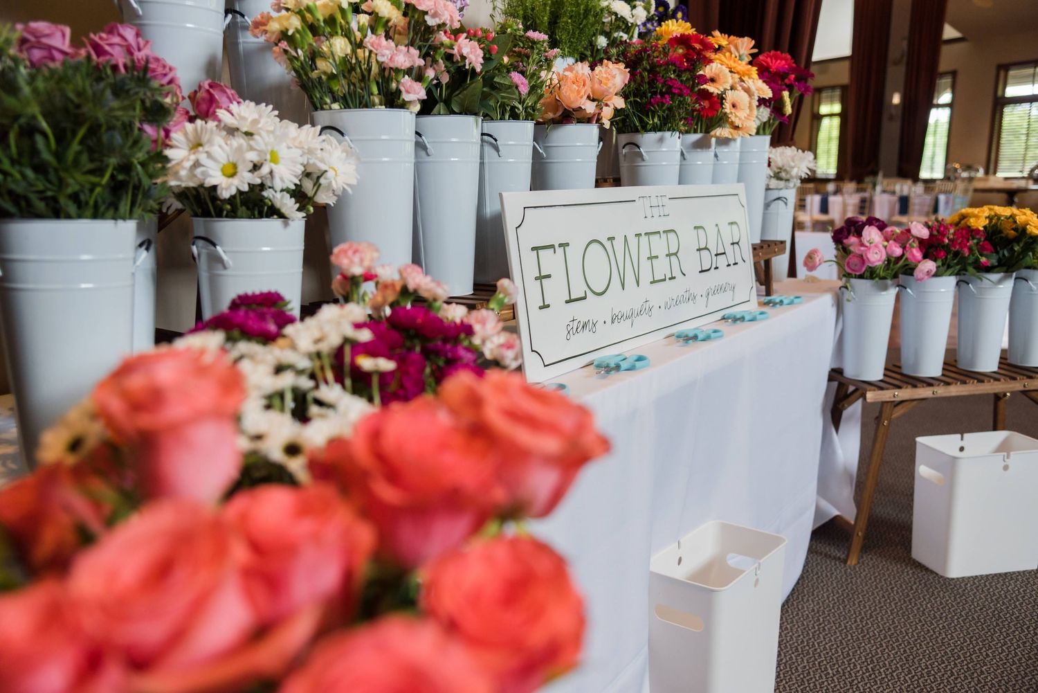 Flower shop display with colorful bouquets in white vases and Flower Bar signage.