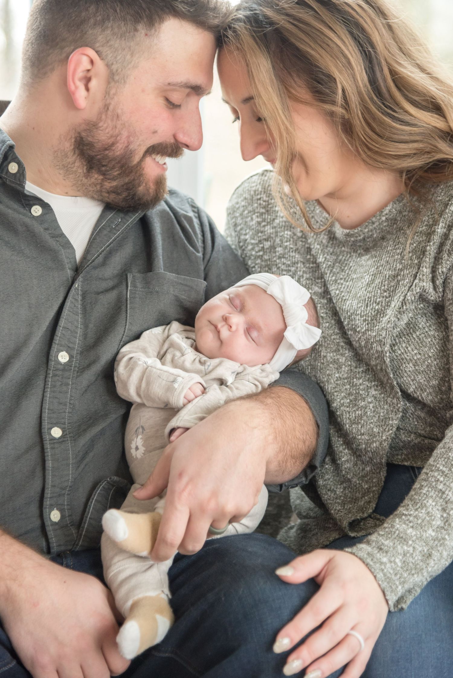 Tender moments of parents bonding with their newborn baby in casual home setting.