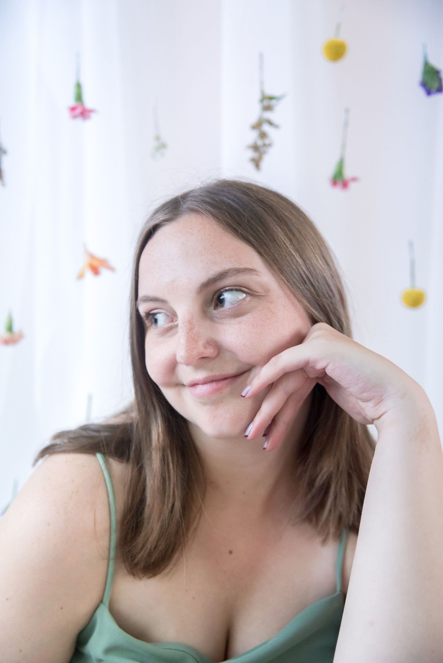 Casual portrait series showing expressive poses against floral backdrop.