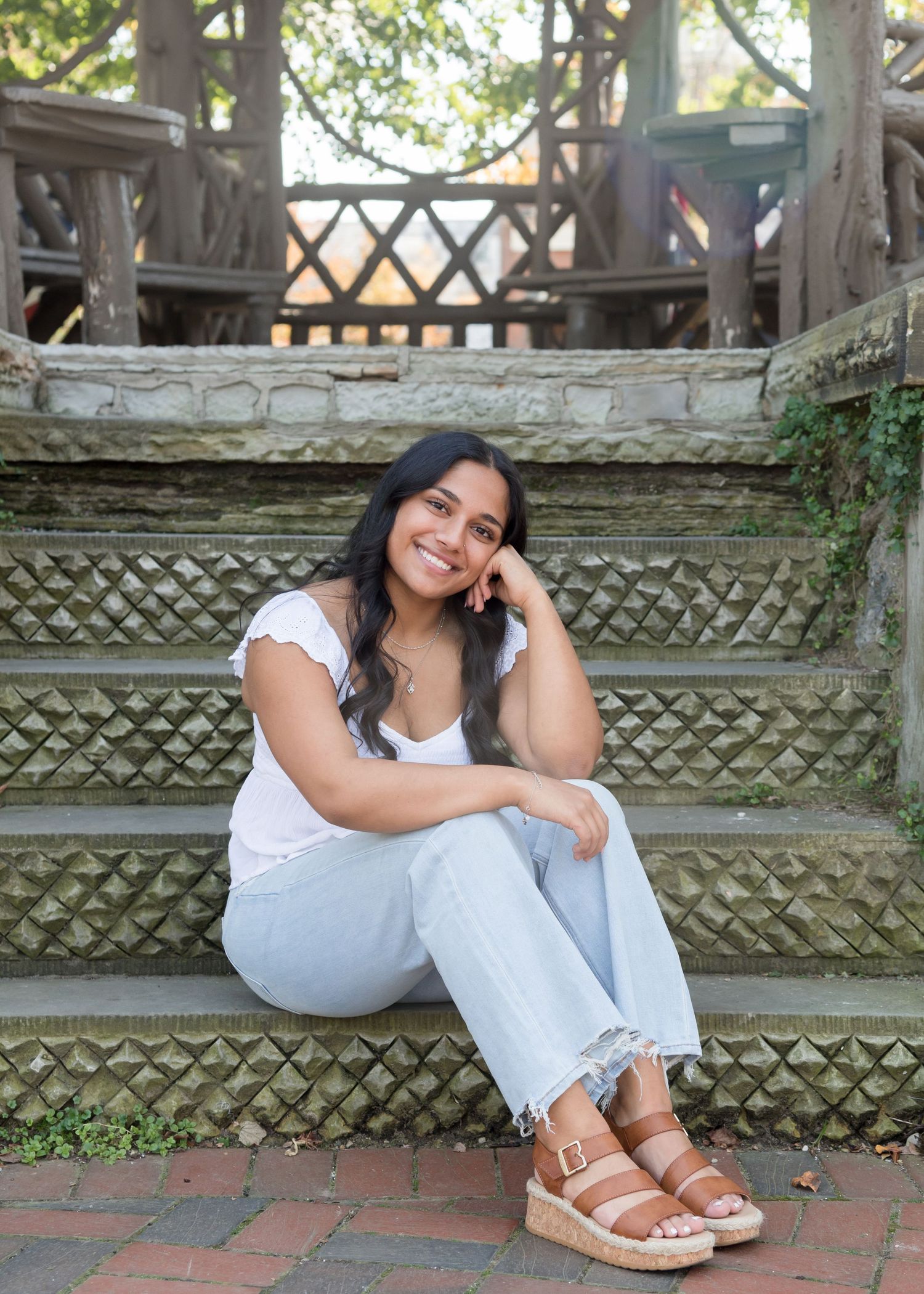Casual portrait on weathered wooden steps with lattice pattern background.