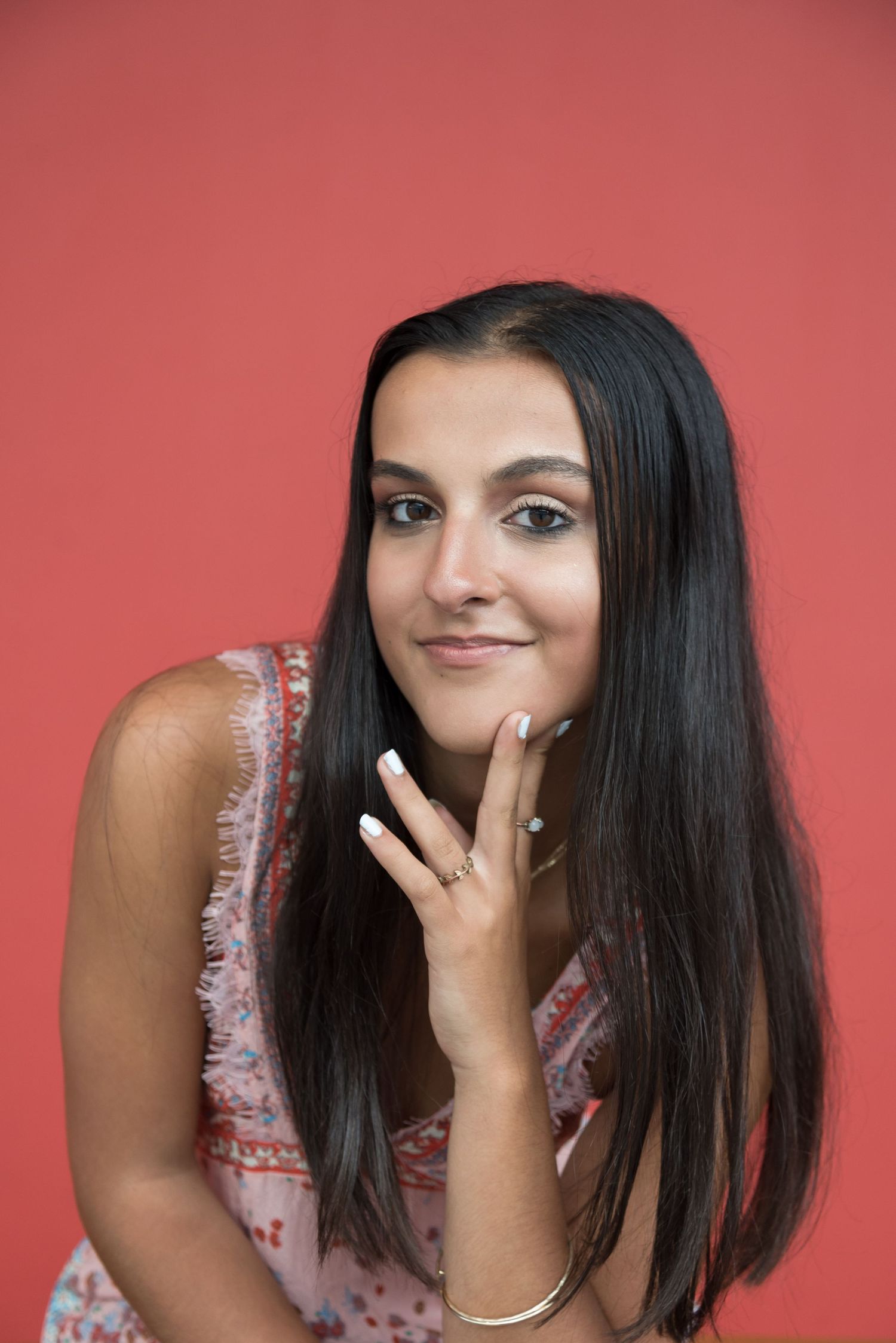 Portrait against coral background showing playful expressions.
