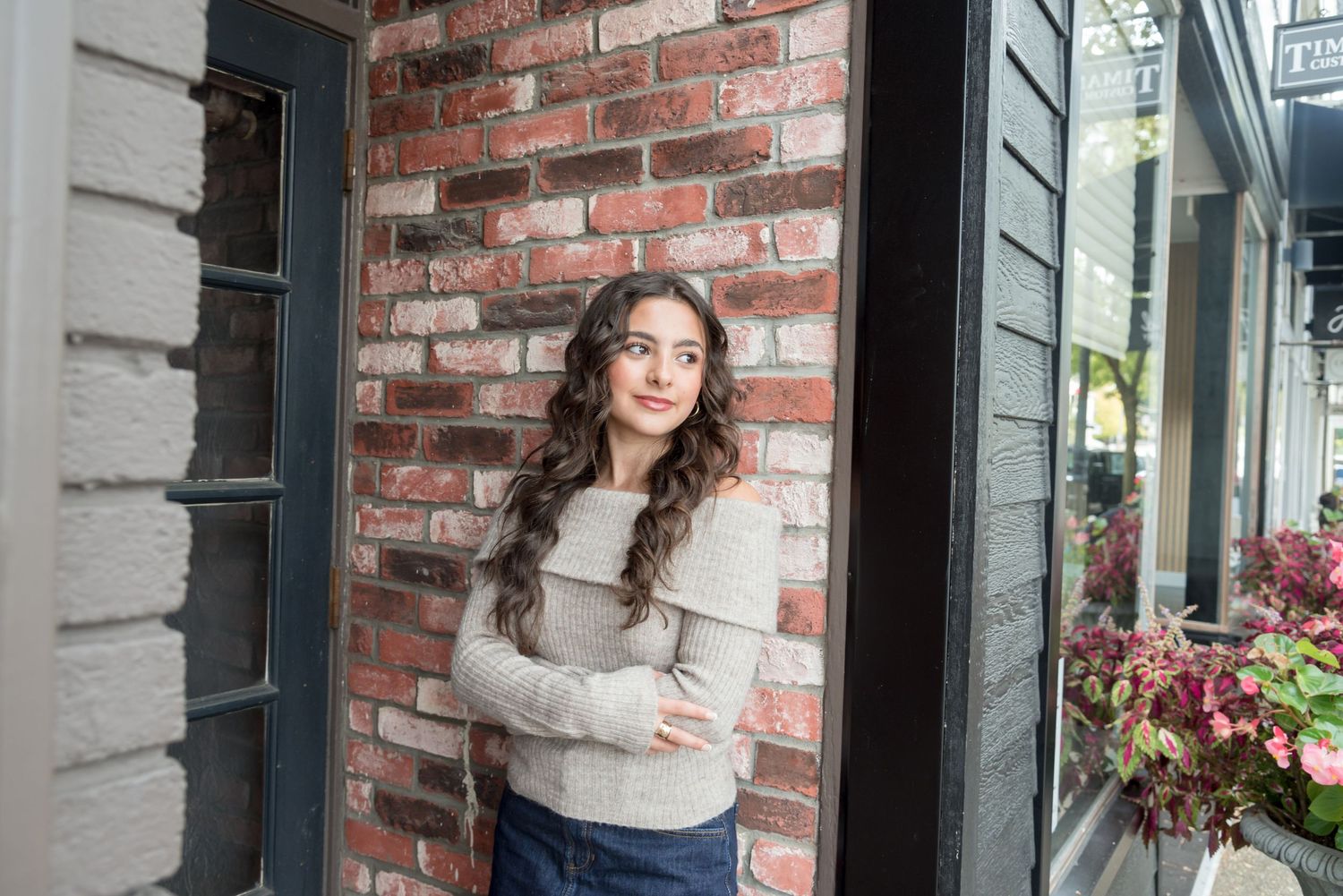 Portrait session against rustic brick wall background with natural lighting.