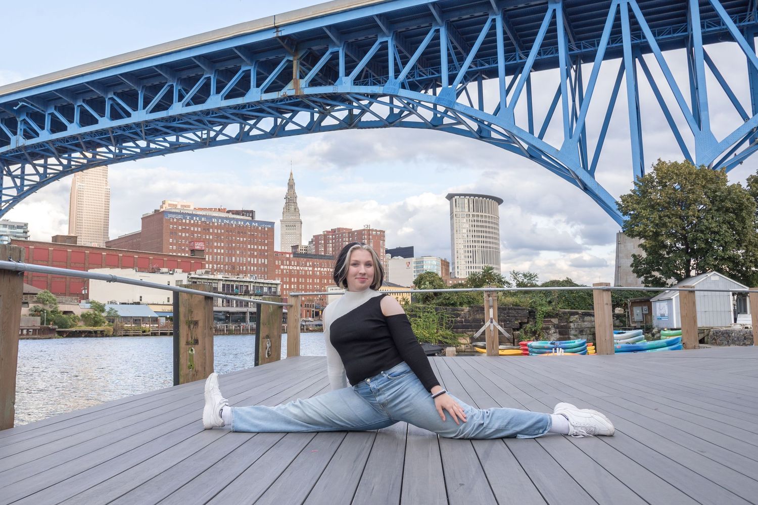Panoramic view of a blue steel bridge spanning across a cityscape.